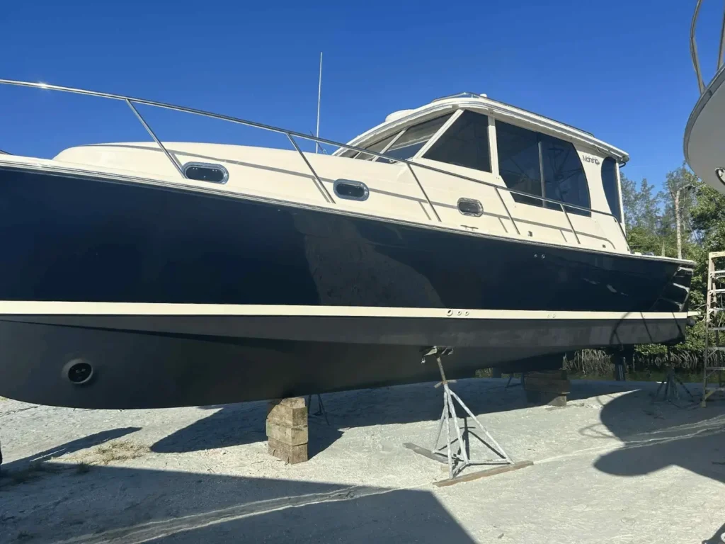 Dark blue cabin cruiser on blocks for professional maintenance and boat watch service