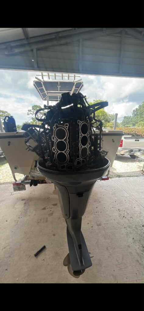 Both cylinder heads removed from a Yamaha 250 outboard during a debris-damaged piston repair in Southwest Florida